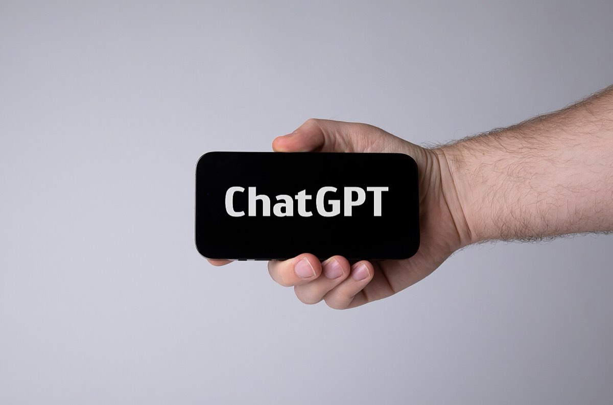 Mão a segurar um telemóvel com a aplicação do ChatGPT aberta