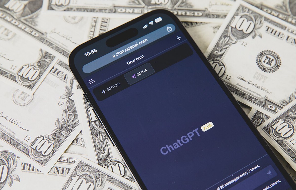 Telemóvel com o ChatGPT aberto pousado sobre notas de dólar